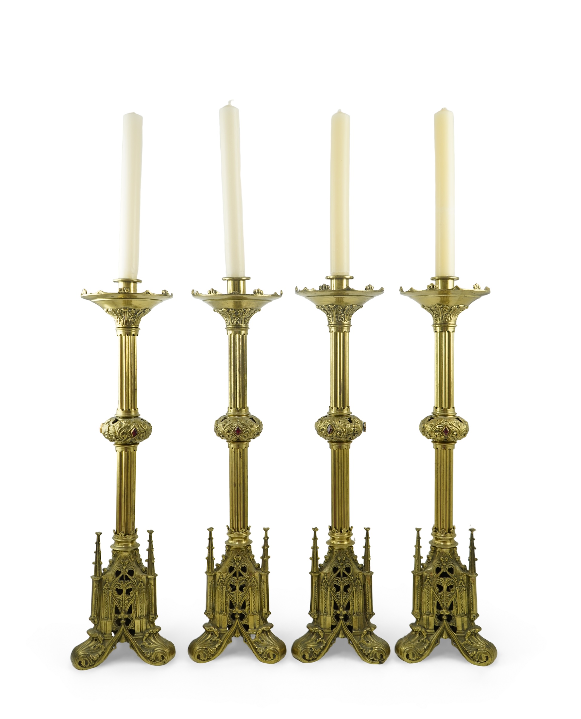 A set of four Gothic revival brass altar candlesticks